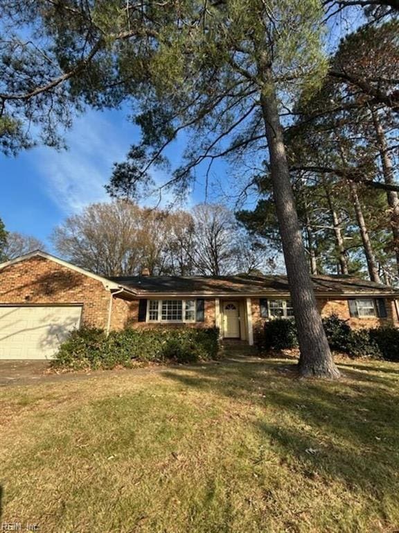 ranch-style home featuring an attached garage and a front lawn