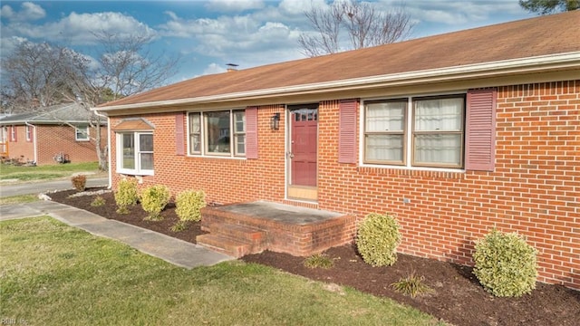 view of front of home with a front yard and brick siding