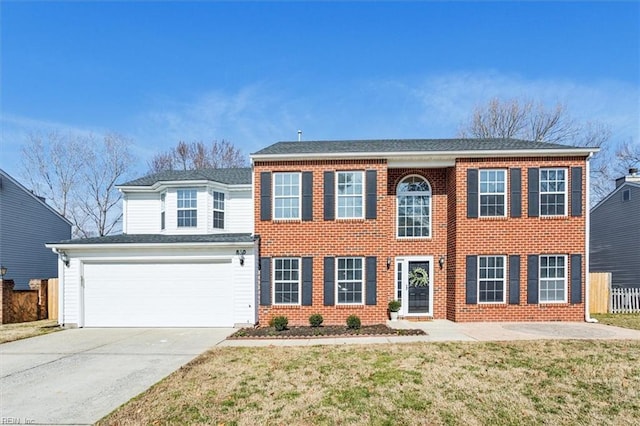 colonial home featuring a garage, brick siding, driveway, and a front lawn