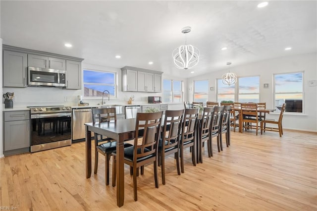 dining room featuring recessed lighting, baseboards, a notable chandelier, and light wood finished floors