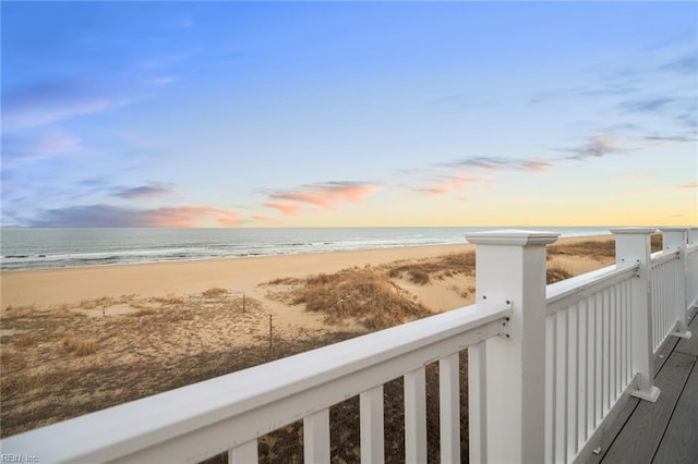 balcony with a water view and a view of the beach