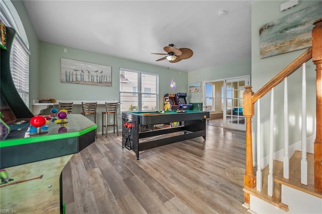 recreation room with billiards, a ceiling fan, wood finished floors, and french doors