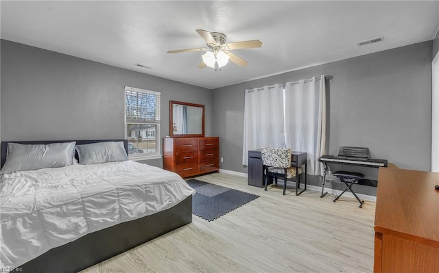 bedroom with visible vents, ceiling fan, light wood-style flooring, and baseboards