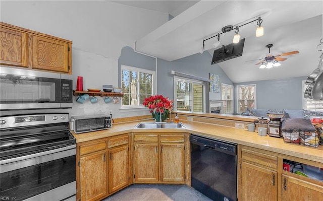 kitchen featuring a sink, stainless steel appliances, light countertops, and lofted ceiling