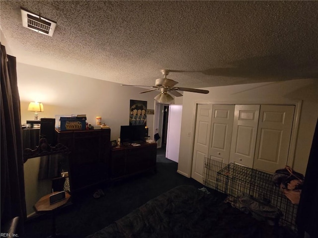 bedroom with visible vents, ceiling fan, dark colored carpet, a textured ceiling, and a closet