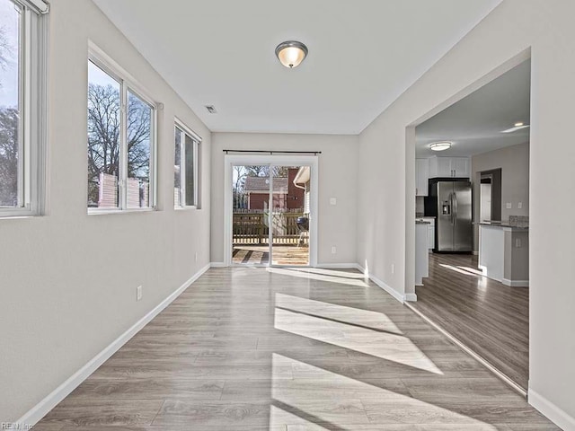 interior space featuring light wood-style flooring and baseboards