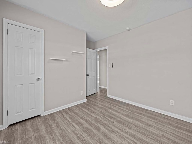 unfurnished bedroom featuring light wood-style flooring and baseboards