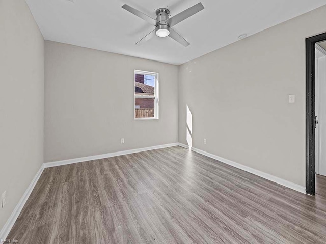 empty room featuring a ceiling fan, baseboards, and wood finished floors