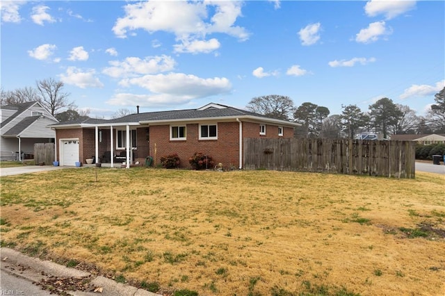 ranch-style house featuring a front yard, an attached garage, fence, and brick siding