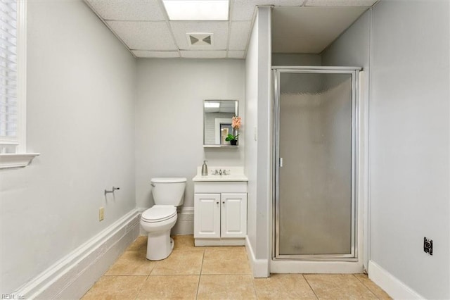 bathroom featuring a paneled ceiling, tile patterned floors, a stall shower, and vanity