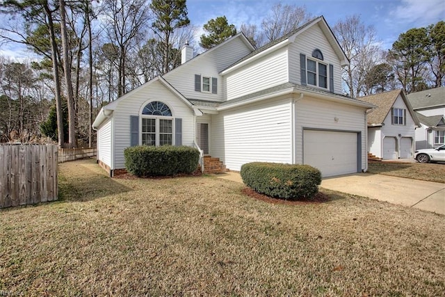 traditional home with a chimney, fence, a garage, driveway, and a front lawn