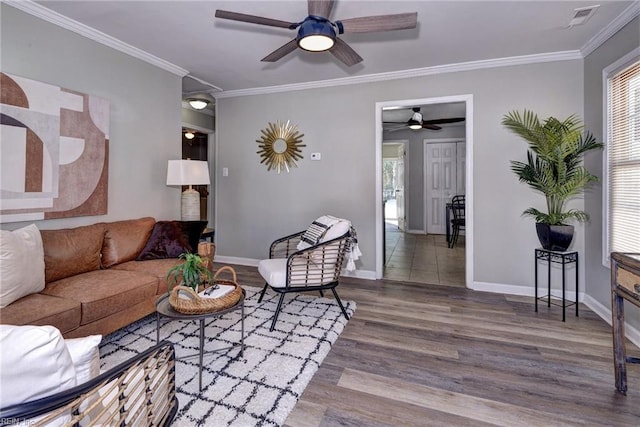 living area featuring ornamental molding, wood finished floors, visible vents, and baseboards