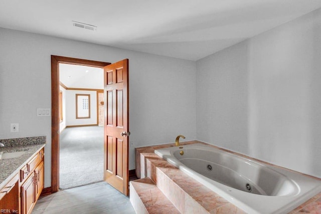 full bathroom featuring visible vents, a jetted tub, and vanity