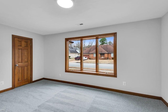 spare room featuring visible vents, baseboards, and light colored carpet