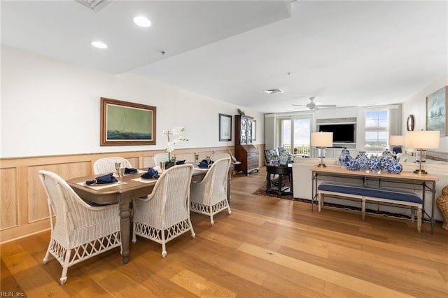 dining space with a wainscoted wall, recessed lighting, a ceiling fan, and light wood-style floors