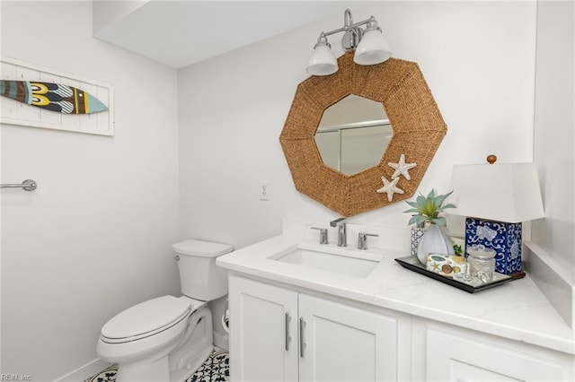 bathroom featuring toilet, baseboards, and vanity