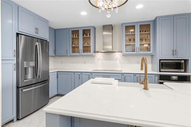 kitchen with recessed lighting, marble finish floor, appliances with stainless steel finishes, wall chimney range hood, and glass insert cabinets