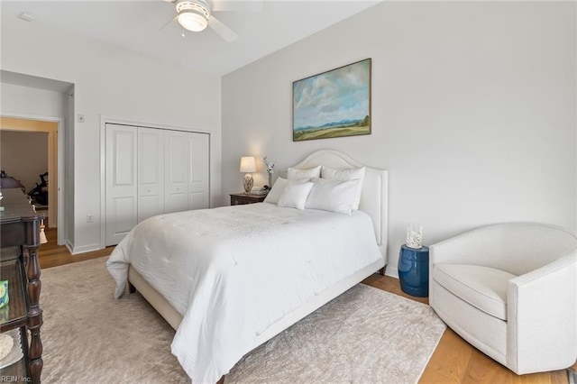 bedroom with a closet, wood finished floors, and a ceiling fan