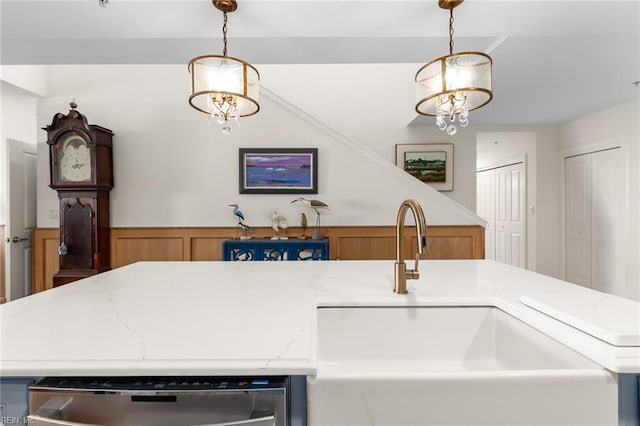 kitchen featuring light countertops, a sink, and pendant lighting