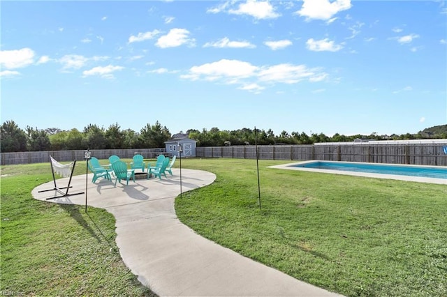 view of yard featuring a storage unit, an outdoor structure, a fenced backyard, and a fenced in pool