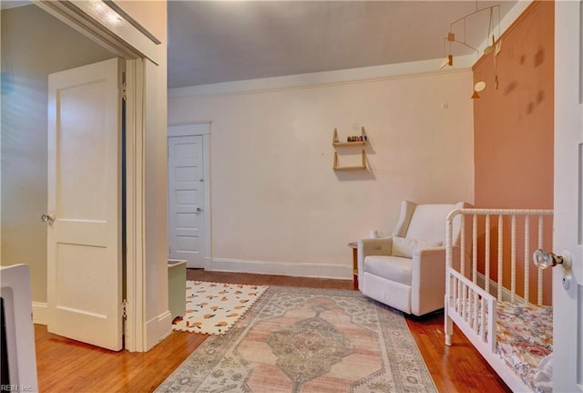 bedroom with baseboards, wood finished floors, and ornamental molding