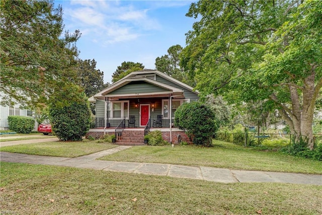 bungalow-style house featuring fence, a front lawn, and a porch