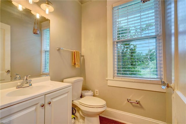 bathroom with vanity, toilet, and baseboards