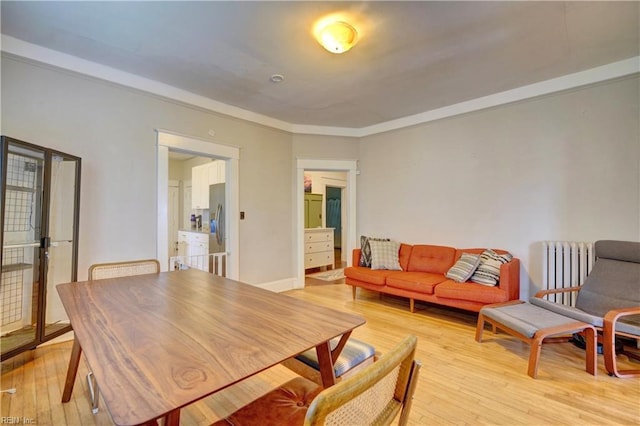 dining space featuring light wood finished floors and radiator heating unit