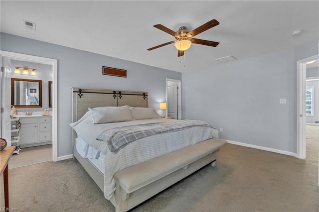 bedroom with light carpet, baseboards, visible vents, ceiling fan, and ensuite bathroom