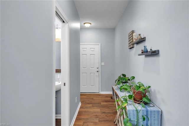 hallway featuring baseboards and dark wood finished floors