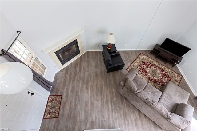 living area with a fireplace, baseboards, and wood finished floors