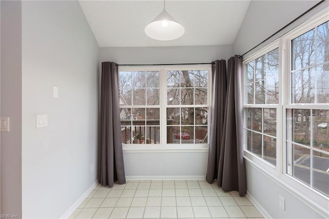 unfurnished dining area featuring lofted ceiling, light tile patterned flooring, and baseboards