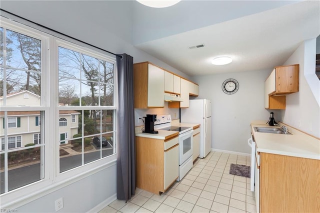 kitchen featuring light countertops, visible vents, a sink, white appliances, and under cabinet range hood