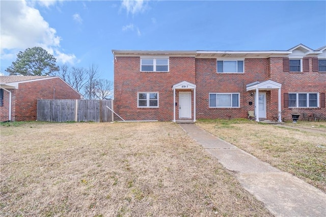 view of front of property with fence, a front lawn, and brick siding