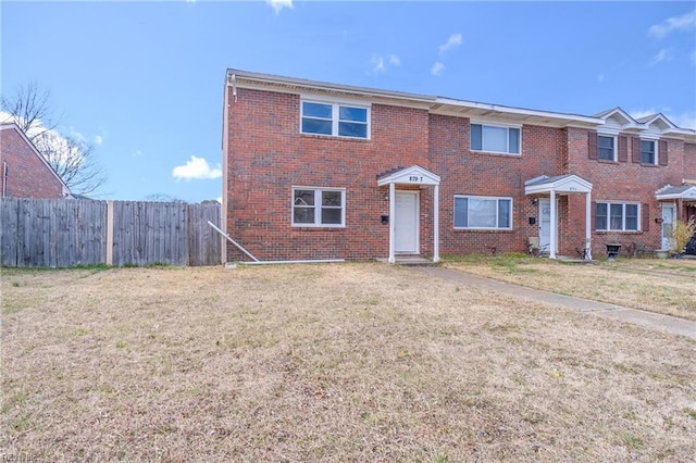 view of front of property featuring a front yard, brick siding, and fence