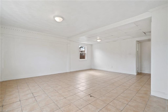 spare room with baseboards and light tile patterned floors