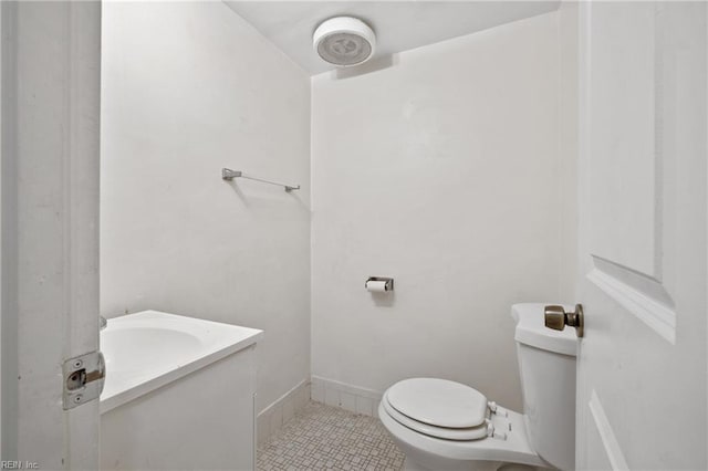 bathroom with tile patterned flooring, vanity, and toilet