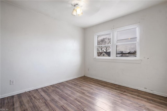 empty room featuring baseboards and wood finished floors