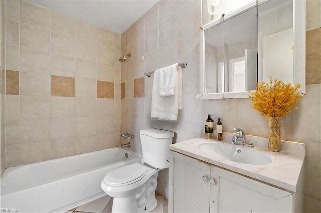 full bath with tile walls, shower / bathing tub combination, toilet, vanity, and tile patterned floors