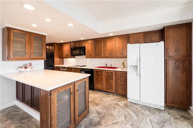 kitchen featuring glass insert cabinets, a peninsula, light countertops, black appliances, and recessed lighting