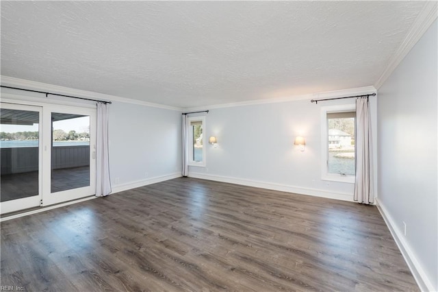 empty room featuring dark wood-style floors, baseboards, ornamental molding, and a textured ceiling