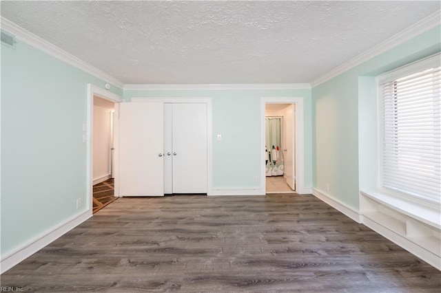 unfurnished bedroom featuring a textured ceiling, dark wood finished floors, and crown molding