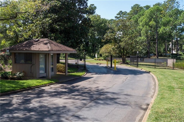 view of street with curbs and a gated entry