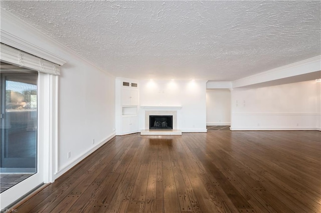 unfurnished living room with a fireplace with raised hearth, a textured ceiling, baseboards, dark wood finished floors, and crown molding