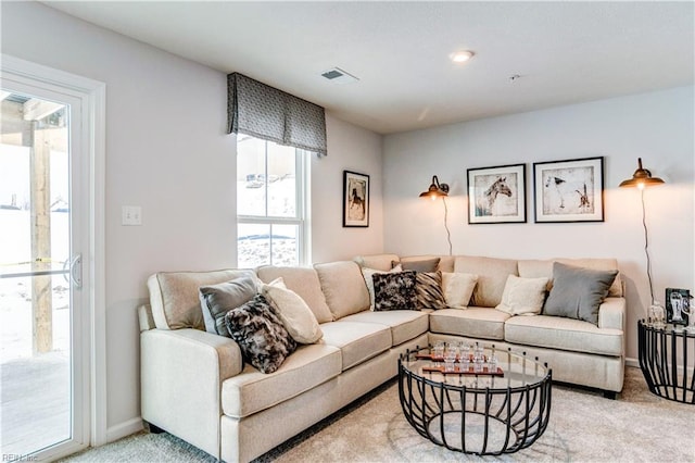 living area with light carpet, visible vents, and baseboards