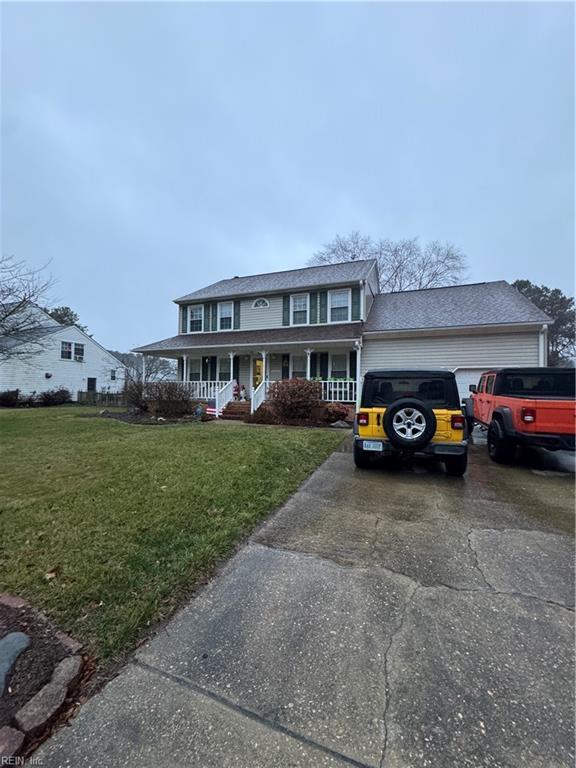 view of front facade featuring a garage, driveway, a porch, and a front yard