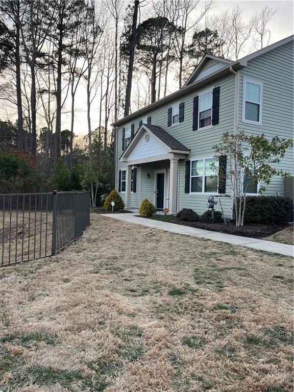 view of front facade with a front yard and fence