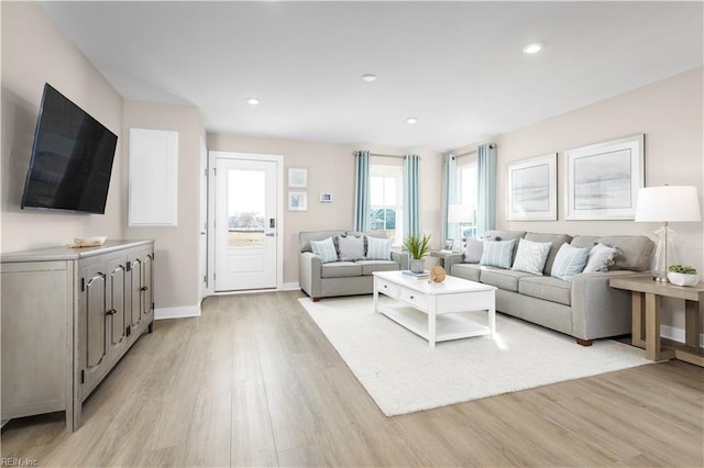 living room with light wood finished floors, baseboards, and recessed lighting