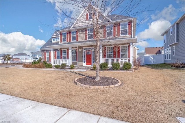 view of front of property with a porch, a front yard, and fence