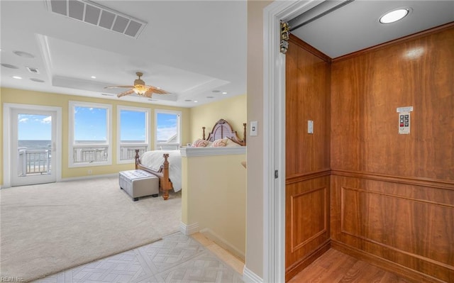 hall with baseboards, visible vents, a raised ceiling, elevator, and recessed lighting